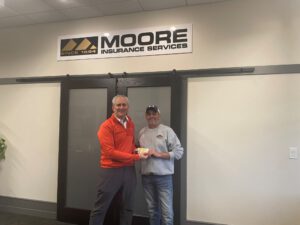 Moore Insurance handing game tickets to Braman Roofing.