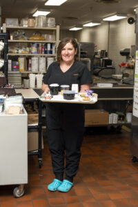 Ashley holding tray of food in dietary unit.