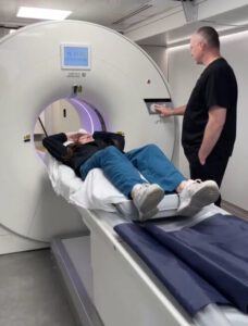 The HCS Group staff members demonstrating PET/CT scanner